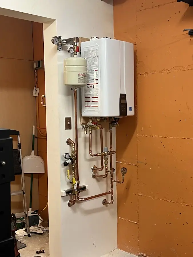 Plumbing technician inspecting water heater connections in Lewes